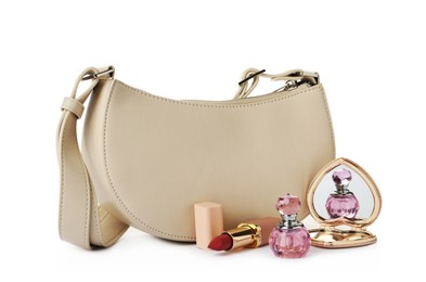 Photo of Stylish baguette bag with perfume, pocket mirror and lipstick on white background