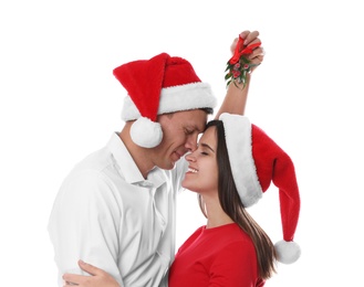 Happy couple under mistletoe bunch on white background