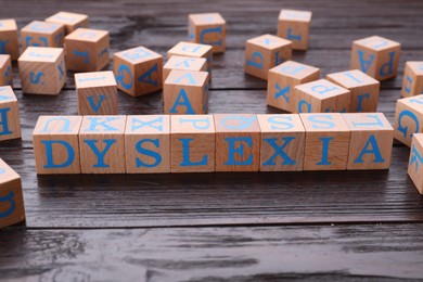 Photo of Cubes with word Dyslexia on wooden table
