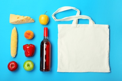 Photo of Flat lay composition with shopping bag and products on color background