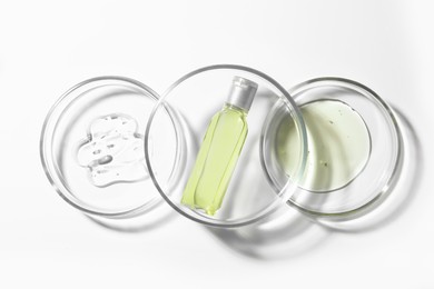 Photo of Petri dishes with samples and bottle on white background, top view