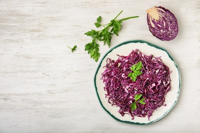 Flat lay composition with chopped purple cabbage and parsley on wooden background