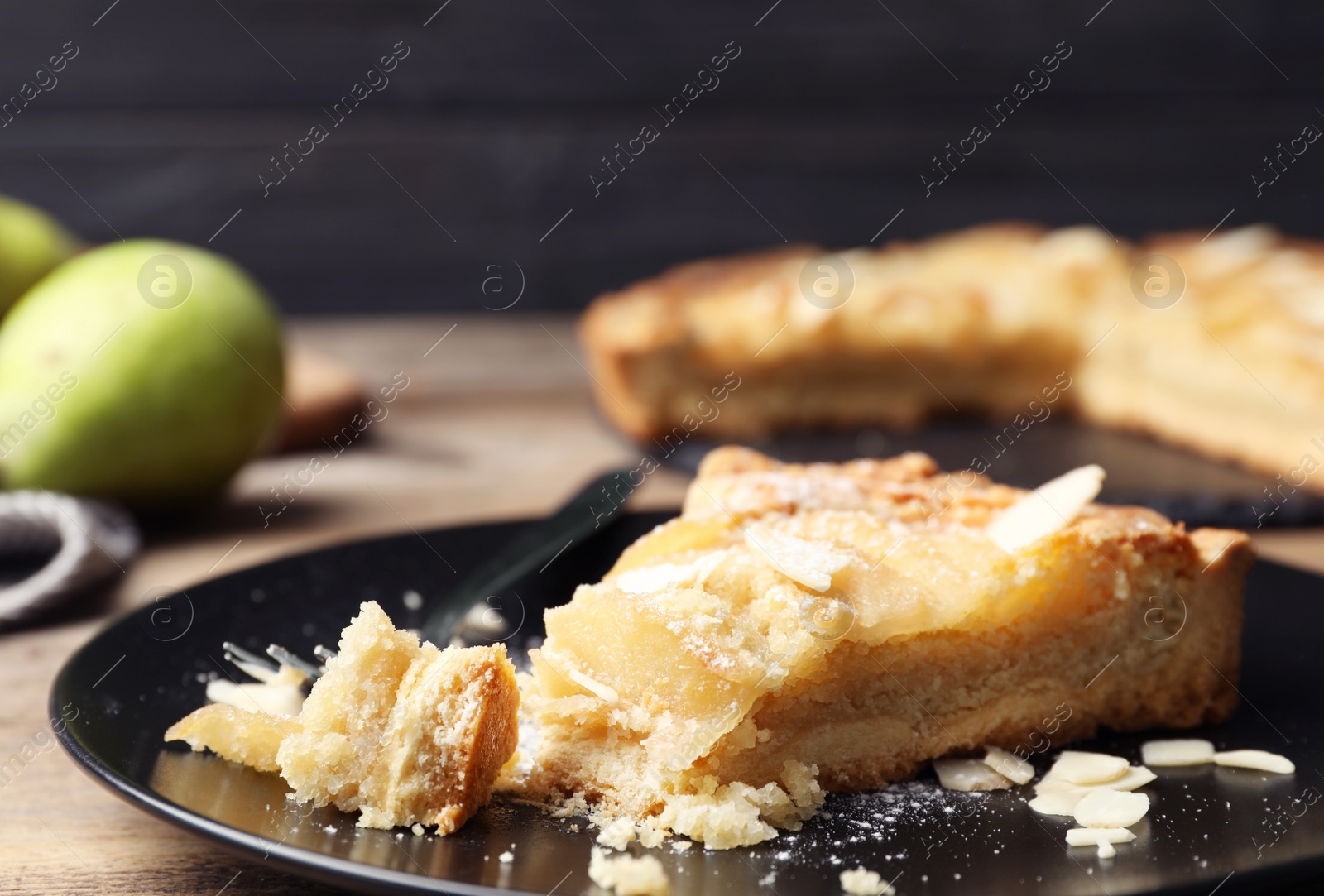 Photo of Piece of delicious sweet pear tart on table, closeup