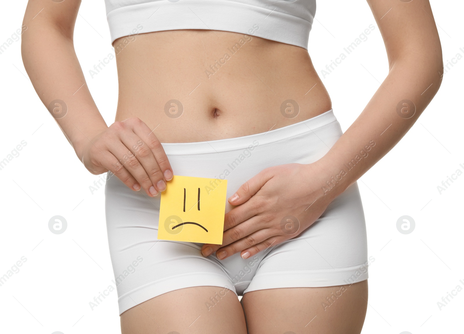 Photo of Woman holding sticky note with drawn sad face and suffering from cystitis on white background, closeup
