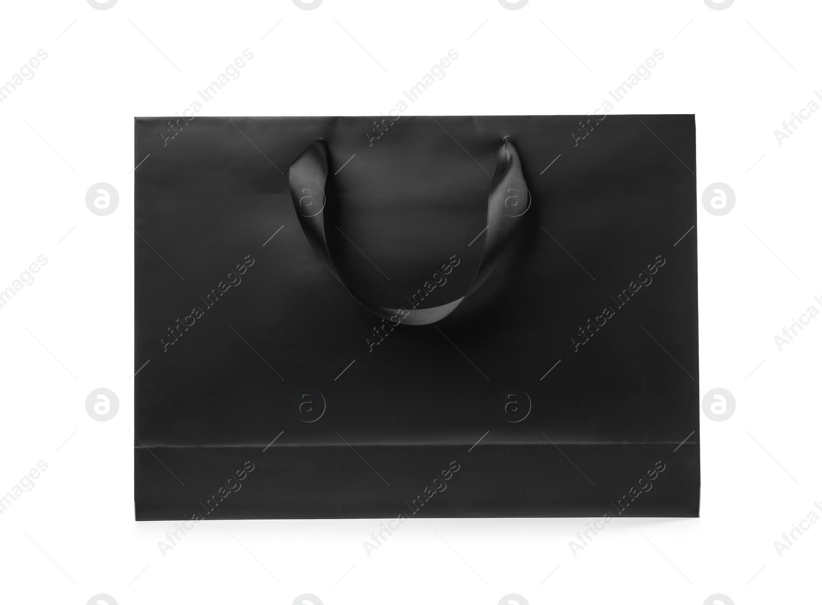 Photo of Paper shopping bag with ribbon handles on white background. Mockup for design