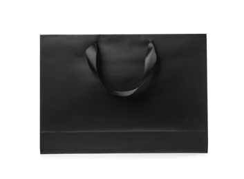 Photo of Paper shopping bag with ribbon handles on white background. Mockup for design