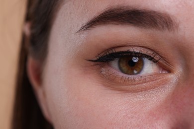 Closeup view of woman with beautiful hazel eyes on beige background