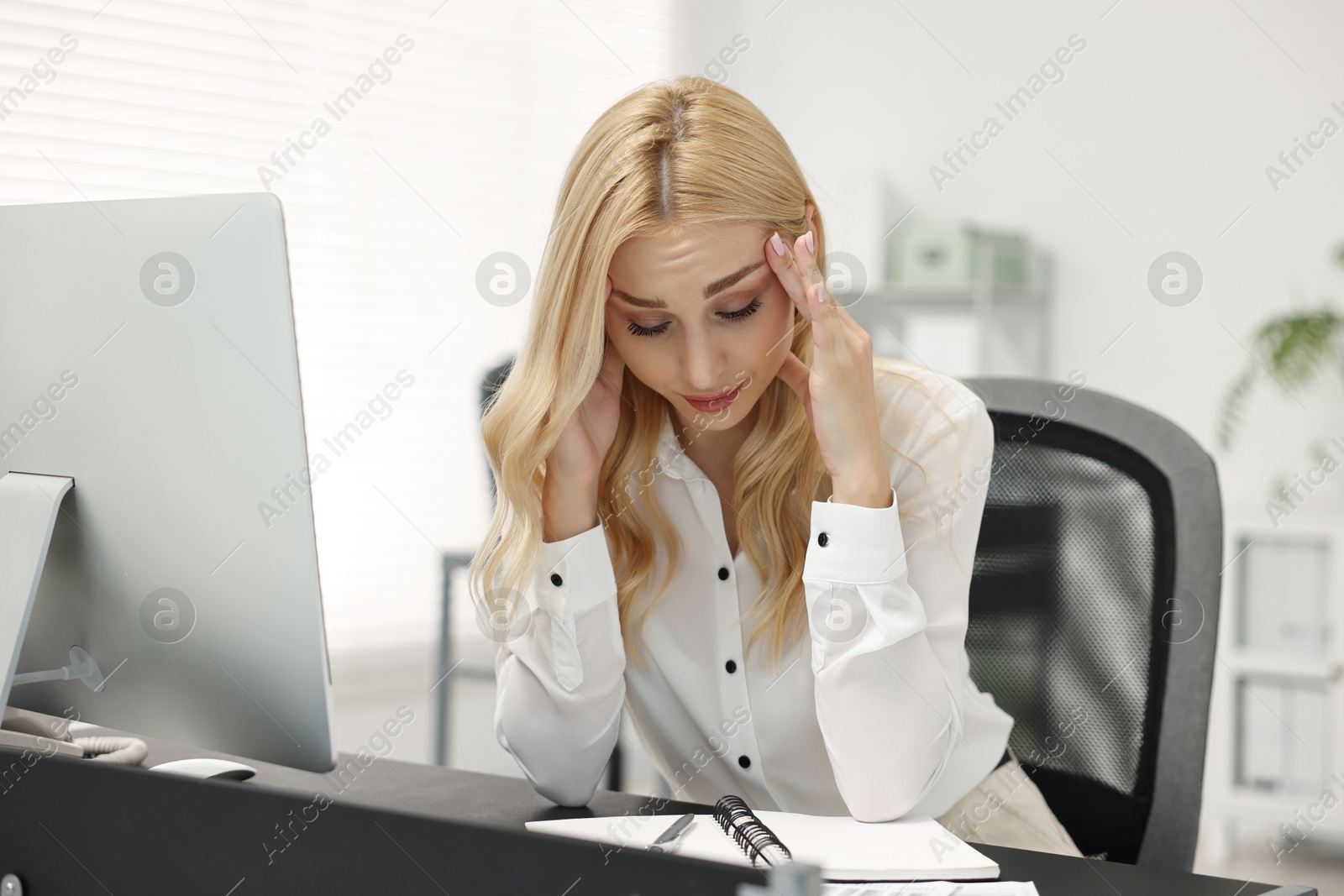 Photo of Overwhelmed woman at table with computer in office