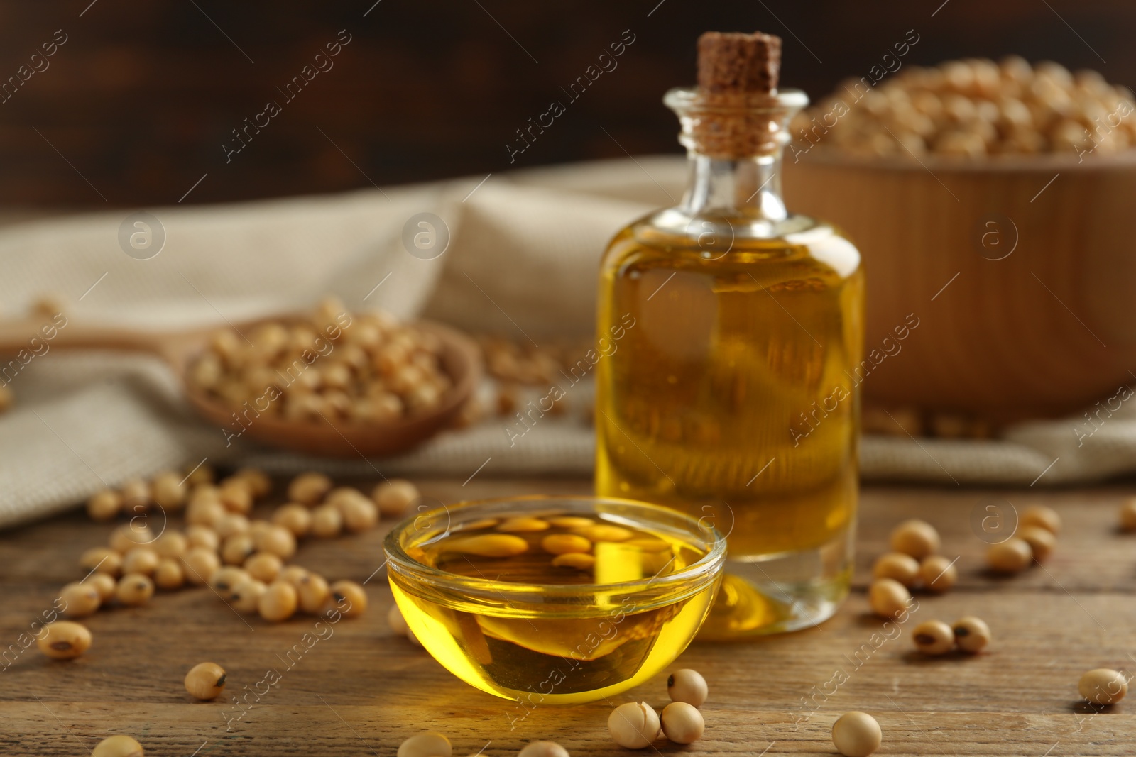 Photo of Composition with soybean oil on wooden table, closeup