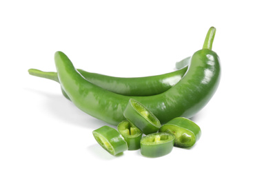 Photo of Cut and whole green hot chili peppers on white background