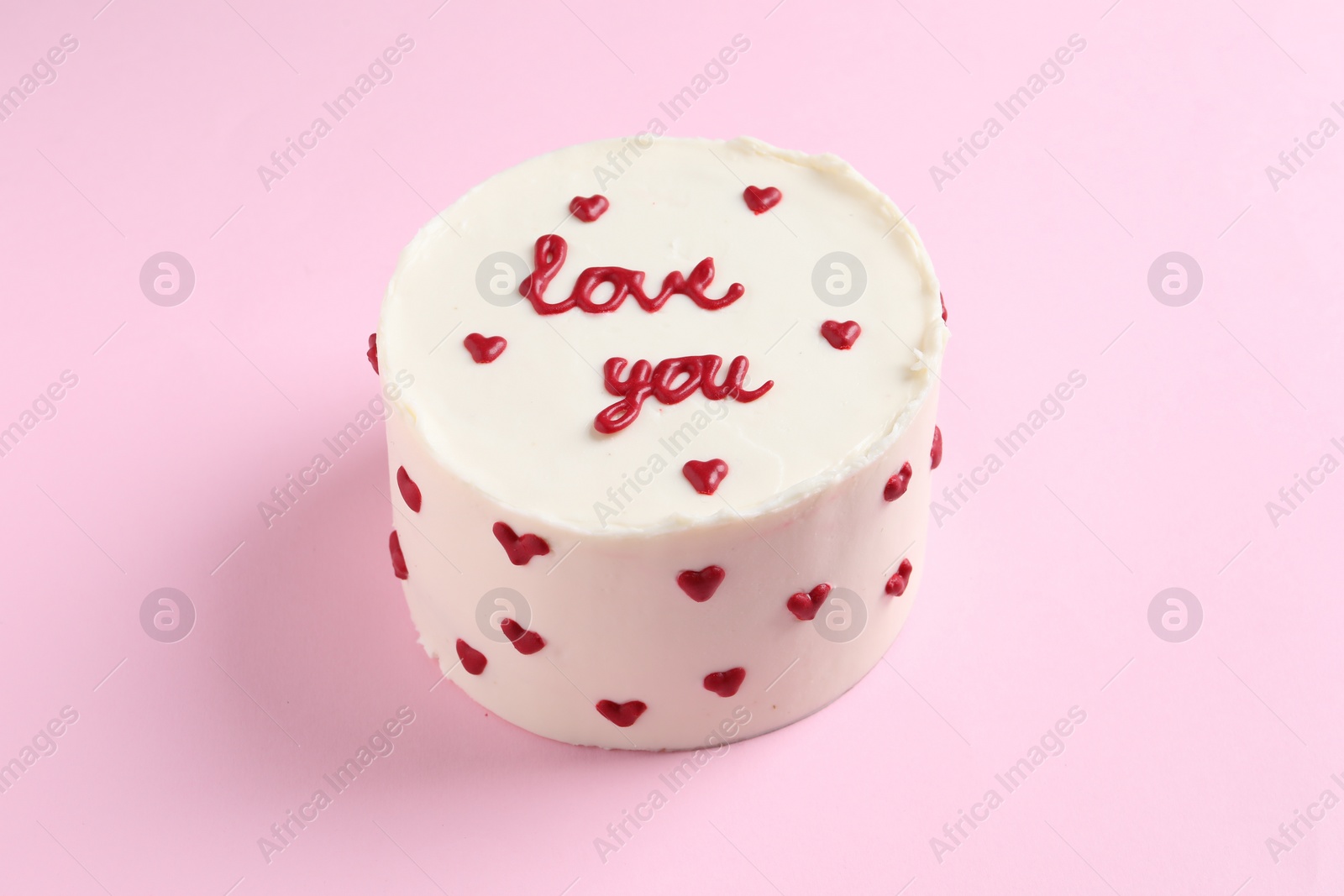 Photo of Bento cake with text Love You on pink table. St. Valentine's day surprise