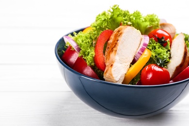 Photo of Delicious salad with chicken and vegetables on white wooden table, closeup