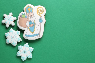 Tasty gingerbread cookies on green background, top view with space for text. St. Nicholas Day celebration