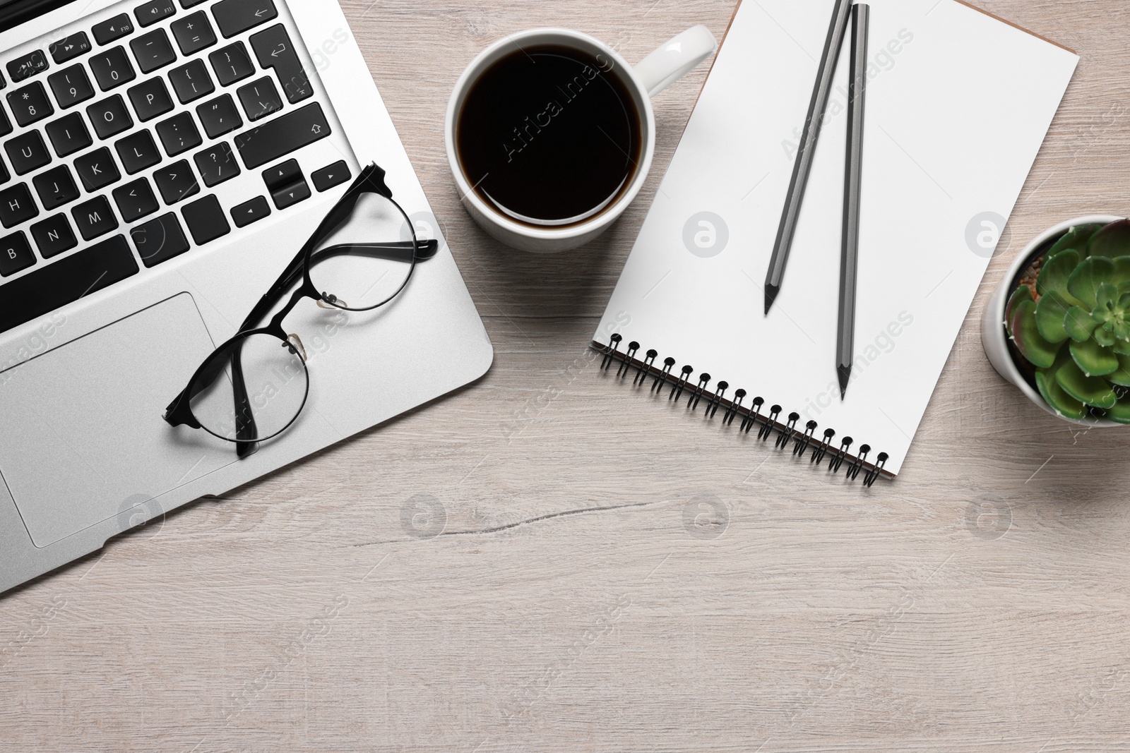 Photo of Home office. Laptop, glasses, coffee, houseplant and stationery on white wooden desk, flat lay. Space for text