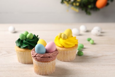 Photo of Tasty decorated Easter cupcakes on wooden table