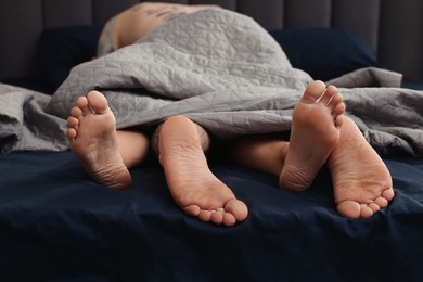 Photo of Passionate couple having sex on bed, focus on legs