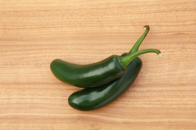 Fresh green jalapeno peppers on wooden table, top view