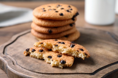 Photo of Delicious cookies with chocolate on wooden board, closeup