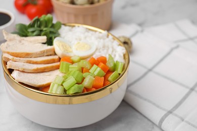 Photo of Delicious poke bowl with meat, egg, rice and vegetables on white marble table, closeup. Space for text