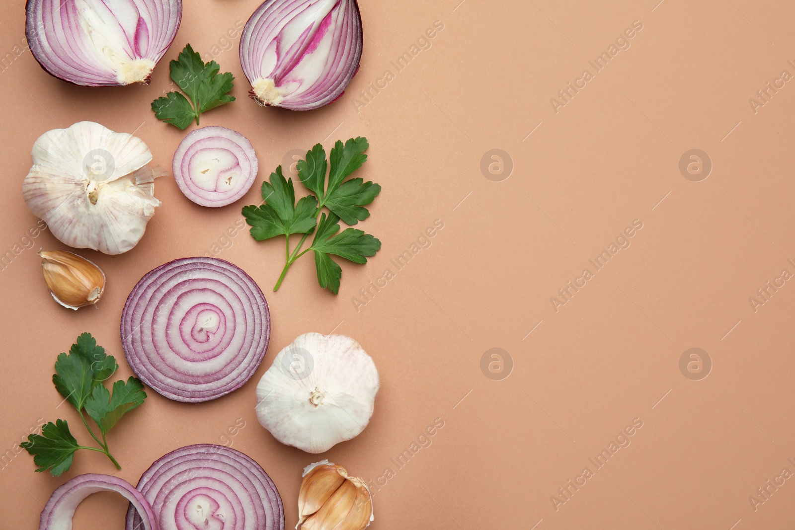 Photo of Fresh red onions, garlic and parsley on beige background, flat lay. Space for text