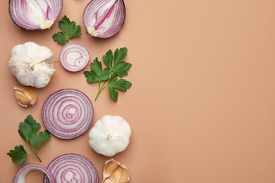 Photo of Fresh red onions, garlic and parsley on beige background, flat lay. Space for text