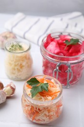 Photo of Delicious sauerkraut prepared according to different recipes on white table, closeup