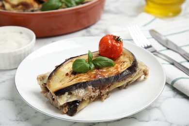 Photo of Plate of delicious eggplant lasagna served on white marble table, closeup