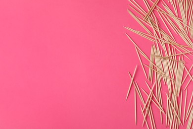 Photo of Wooden toothpicks on pink background, flat lay. Space for text