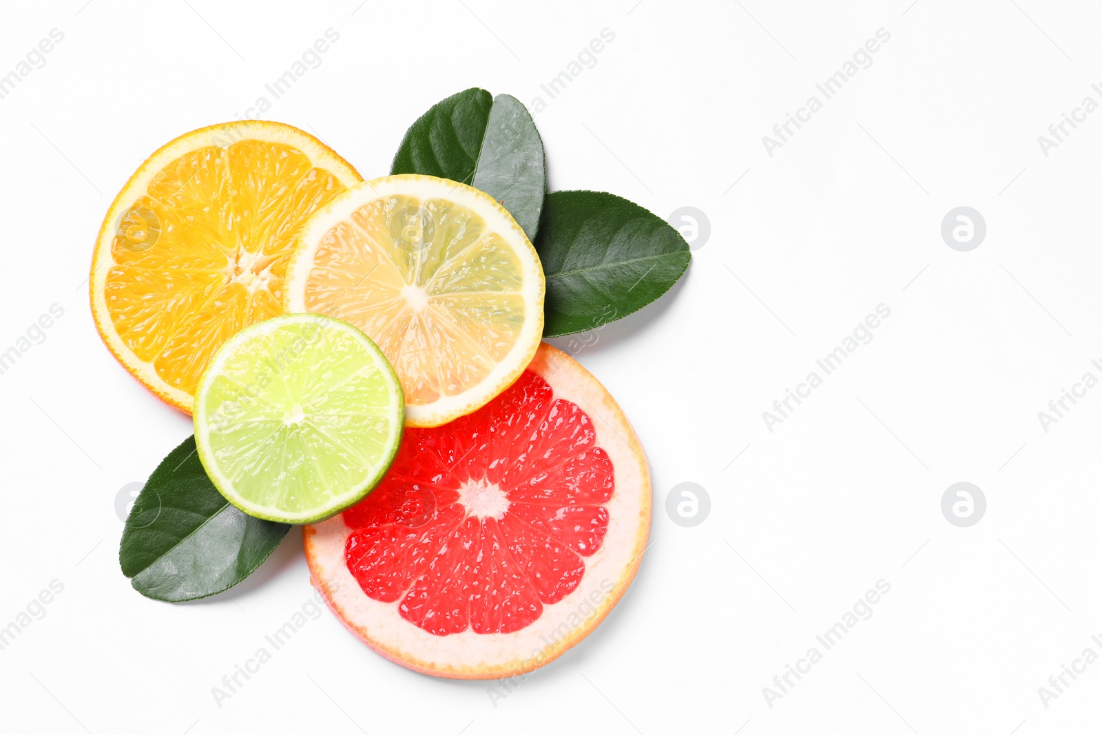 Photo of Slices of fresh ripe citrus fruits and green leaves on white background, flat lay. Space for text