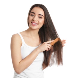 Beautiful young woman with hair comb on white background