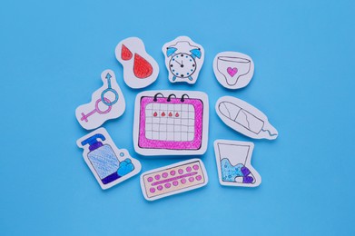 Photo of Woman`s health. Different paper figures on light blue background, flat lay