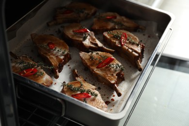 Photo of Delicious roasted ribs on baking tray in oven