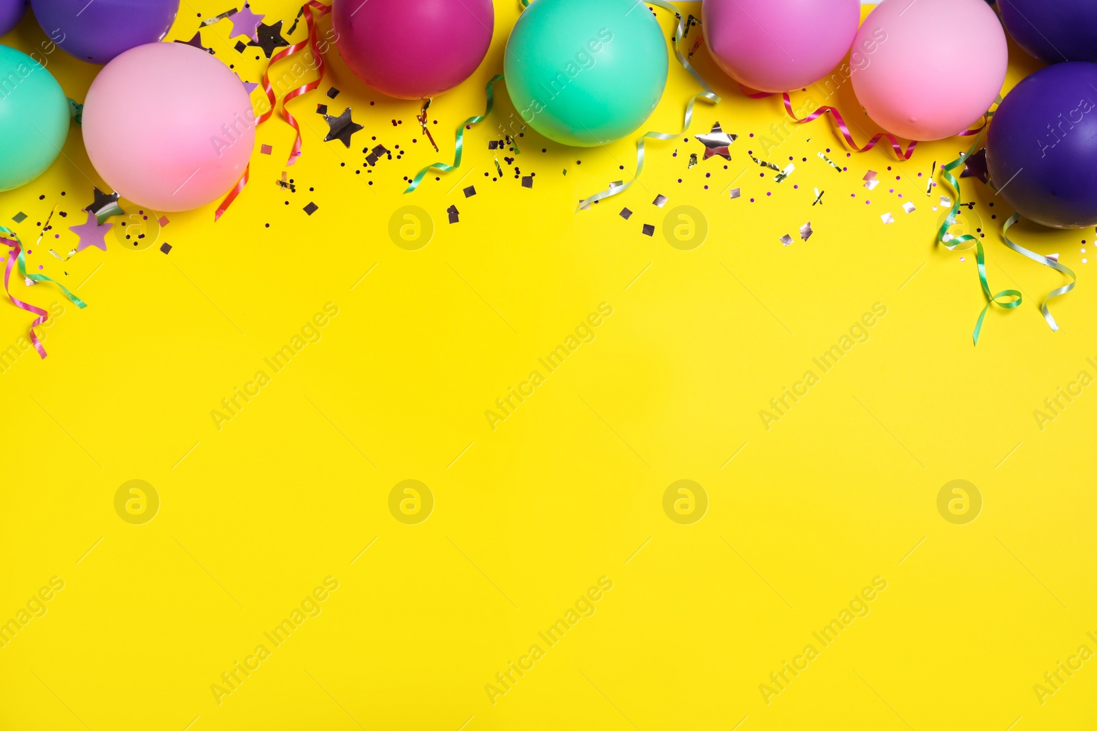 Photo of Flat lay composition with balloons and confetti on yellow background, space for text. Birthday decor