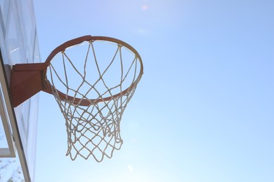 Photo of Basketball hoop with net outdoors on sunny day. Space for text