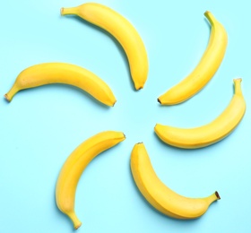 Ripe tasty bananas on blue background, flat lay