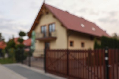 Photo of Beautiful house near fence outdoors, blurred view. Real estate for rent