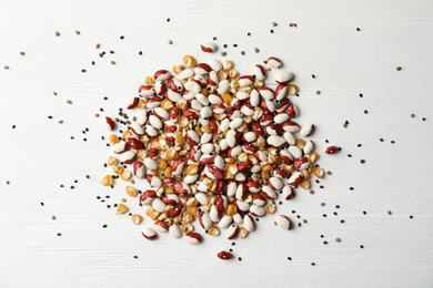 Mixed vegetable seeds on white wooden background, flat lay