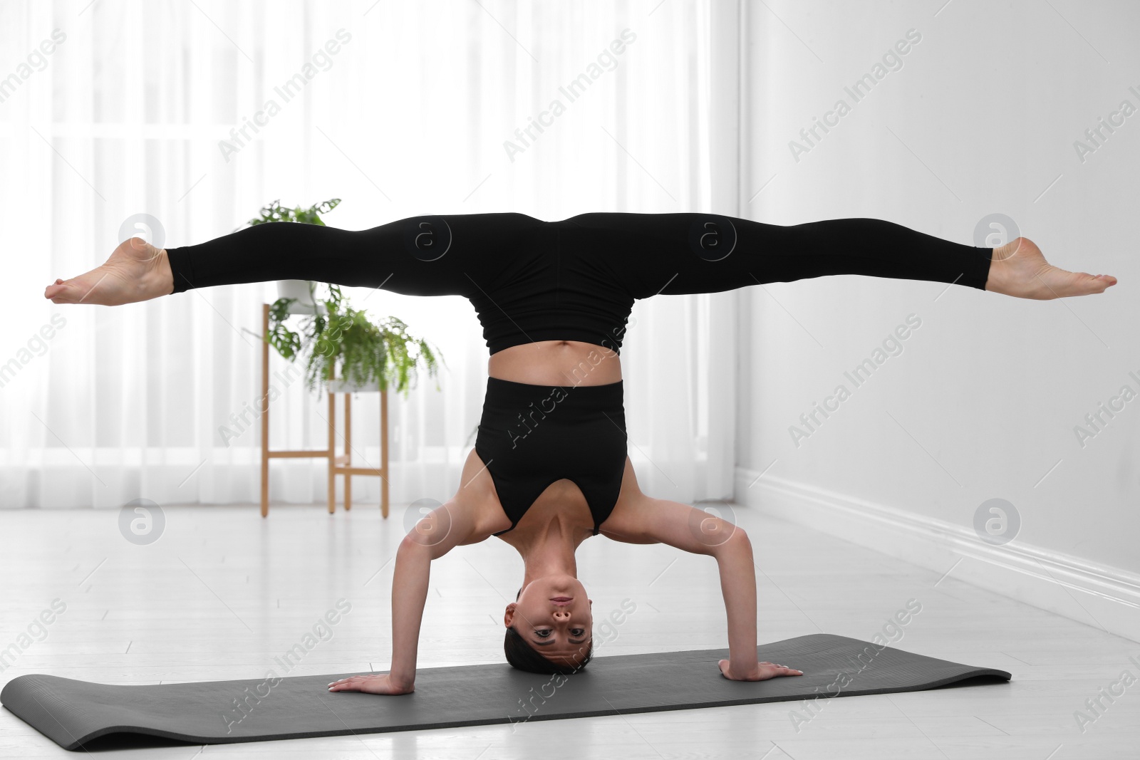 Photo of Professional young acrobat practicing yoga at home