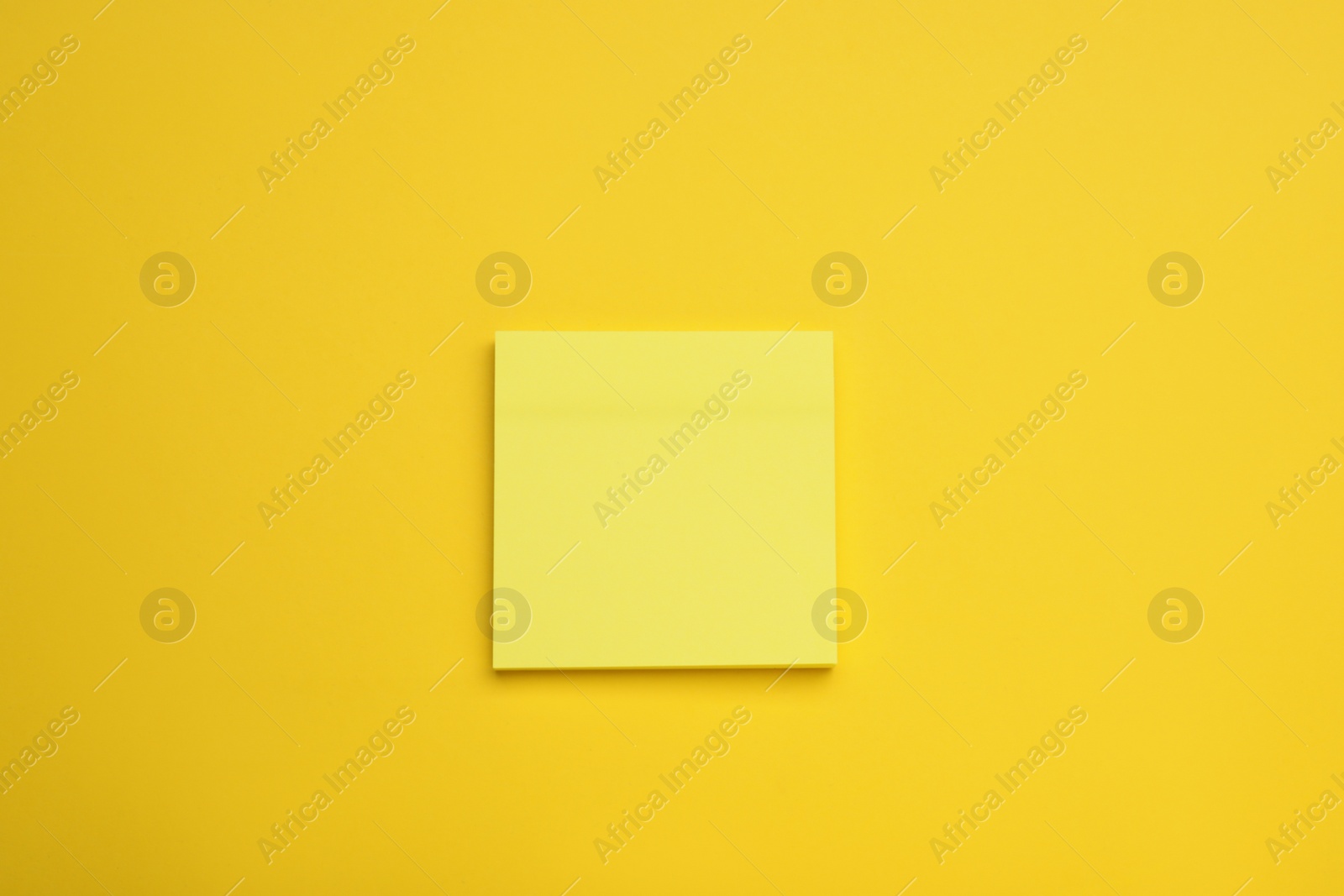 Photo of Paper note on yellow background, top view