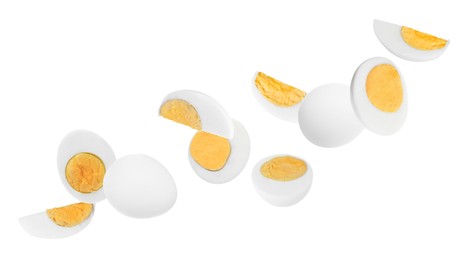 Image of Tasty hard boiled eggs falling on white background