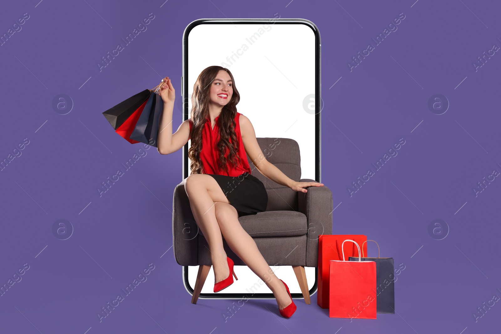 Image of Online shopping. Happy woman with paper bags sitting in armchair near smartphone on dark violet background