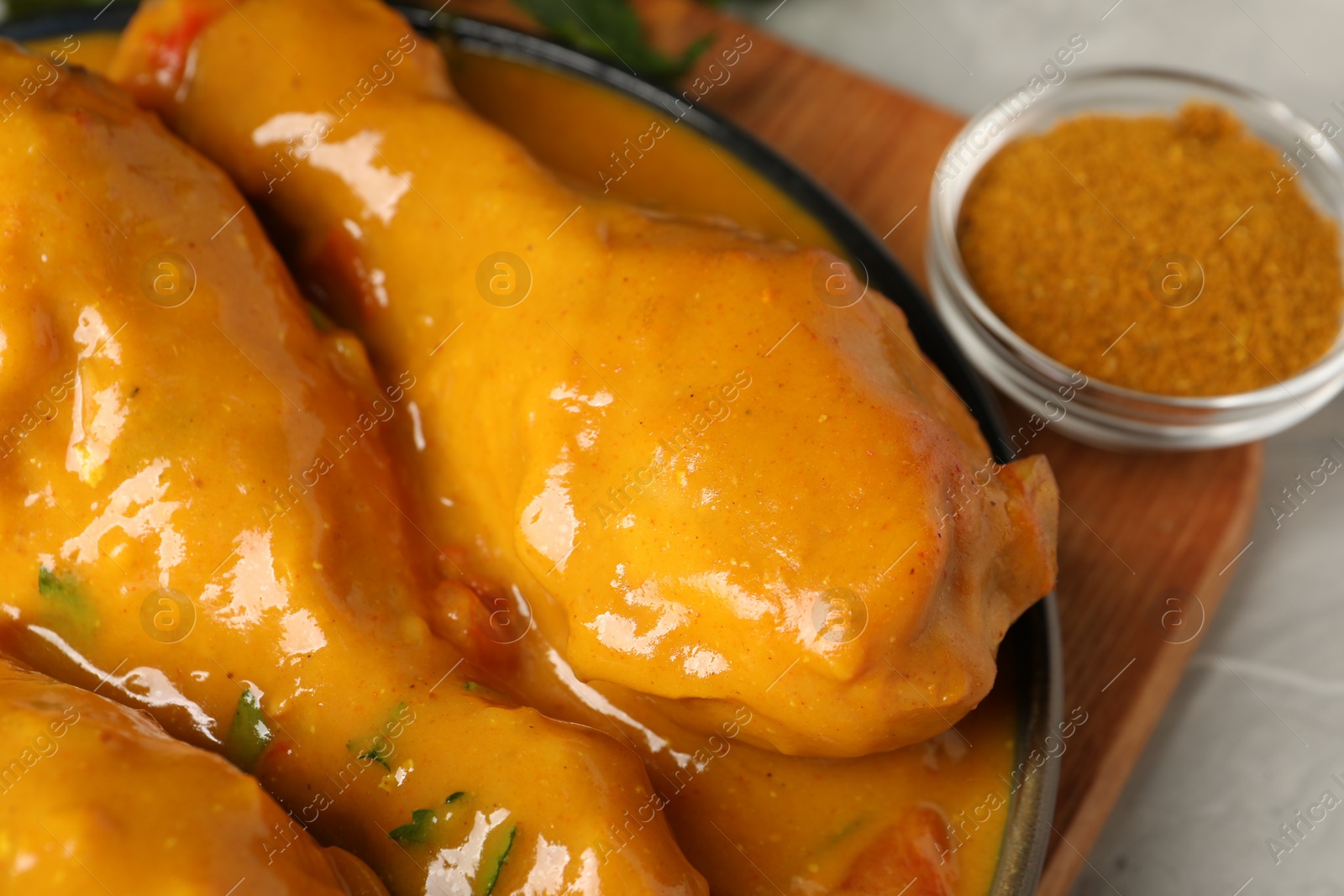 Photo of Tasty chicken curry and spice on grey textured table, closeup
