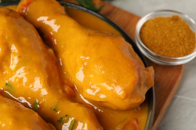 Tasty chicken curry and spice on grey textured table, closeup