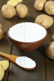 Photo of Starch and fresh potatoes on wooden table