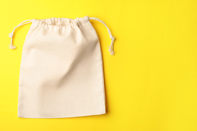 Photo of Cotton eco bag on yellow background, top view. Space for text