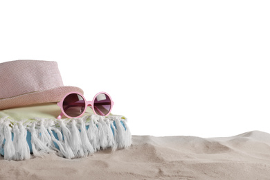 Folded towel, hat and sunglasses on sand against white background, space for text. Beach objects