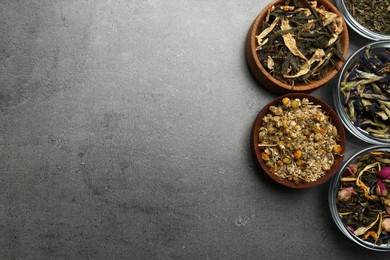 Flat lay composition with different dry teas on grey table, space for text