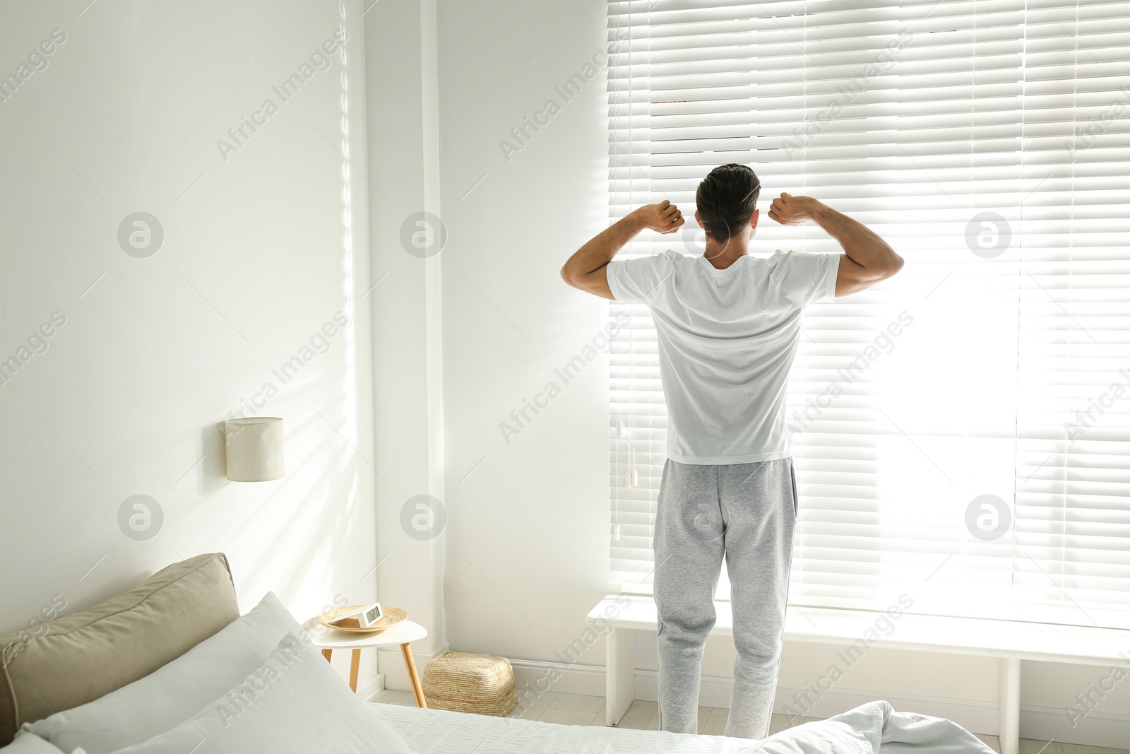 Photo of Man near window in bedroom. Lazy morning