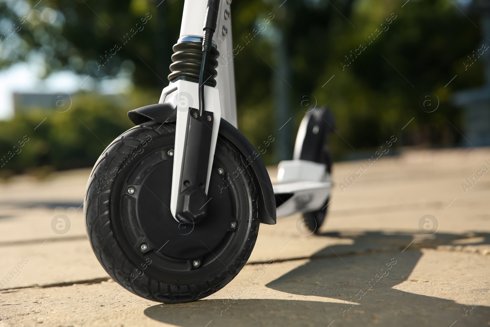 Photo of Modern electric kick scooter outdoors on sunny day, closeup