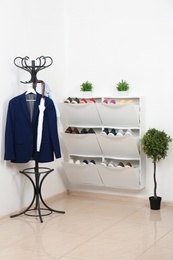 Shoe cabinet with footwear in room. Storage ideas